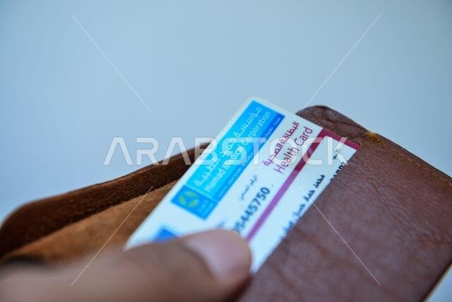 بطاقة الهوية القطرية والبطاقة الطبية باللون البني على خلفية بيضاء