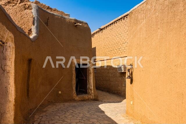 شارع ضيق في قرية المجمعة العربية التقليدية المبنية من الطوب اللبن، المملكة العربية السعودية
