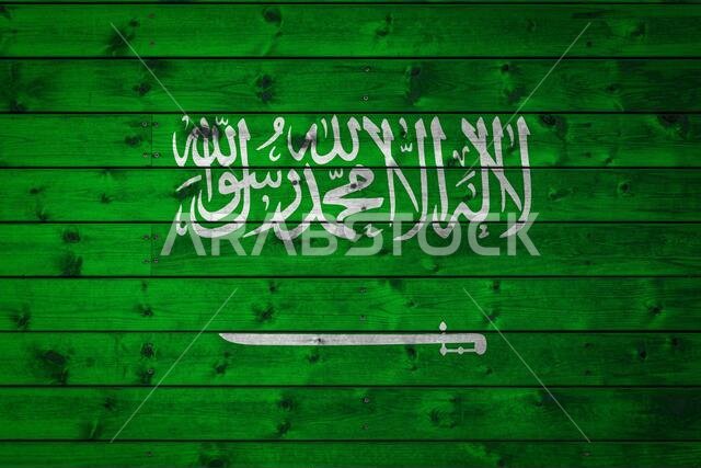 العلم الوطني للمملكة العربية السعودية مرسوم على إطار من ألواح خشبية متساوية مثبتة بمسامير. إنه رمز الدولة.