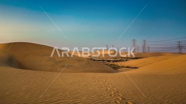 برج كهرباء عالي الجهد عند شروق الشمس بالقرب من الهفوف - المملكة العربية السعودية.