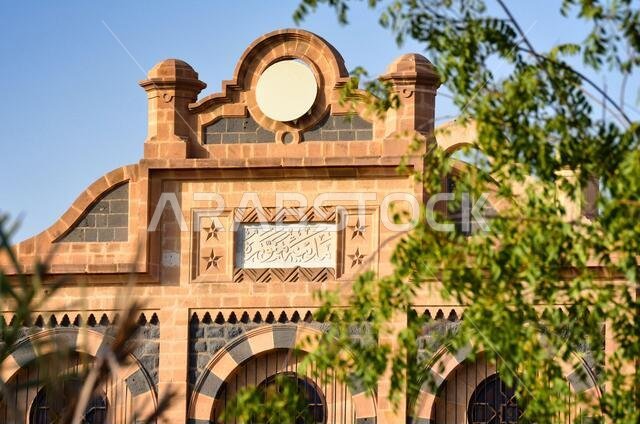 واجهة المبنى الرئيسي لمحطة سكة حديد المدينة المنورة، تظهر اللوحة التي تحمل اسم المدينة (المدينة المنورة) محفورًا باللغة العربية.