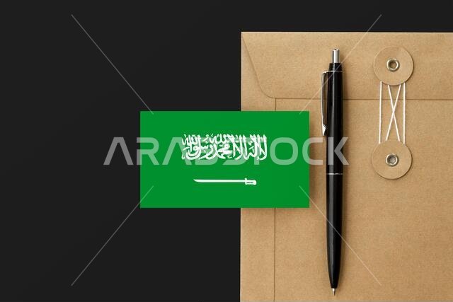 علم المملكة العربية السعودية على ظرف ورقي وخلفية مكتوبة بقلم أسود. فكرة دعوة وطنية. دعوة لموضوع تعليمي.