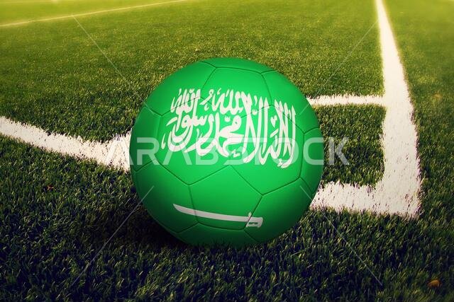 علم المملكة العربية السعودية على الكرة عند ركلة الزاوية، وخلفية ملعب كرة القدم. شعار كرة القدم الوطني على العشب الأخضر.