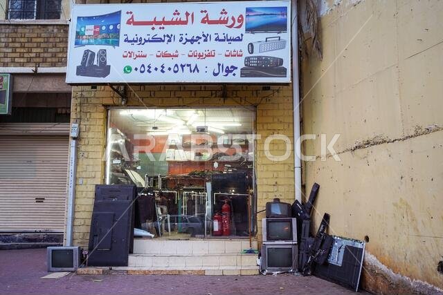 أبها / المملكة العربية السعودية - 23 يناير 2020: محلات إلكترونيات في شارع تجاري تعرض أجهزة تلفزيون قديمة في واجهاتها