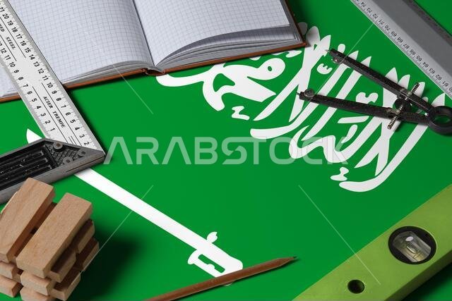 Saudi Arabia national flag on profession concept with architect desk and tools background. Top view mock-up.