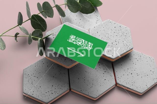 Saudi Arabia flag on hexagon stylish stones. Pink copy space background. Flat lay, top view minimal national concept.