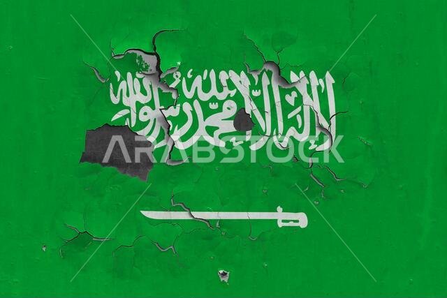 صورة مقربة لعلم المملكة العربية السعودية، قديم، متضرر ومتسخ، معلق على جدار، يتقشر طلاؤه ليكشف عن سطحه الداخلي. مفهوم وطني عتيق.