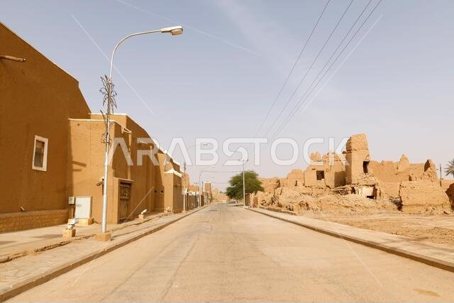 شارعٌ يضم بيوتاً طينية متداعية في مدينة شقراء بالمملكة العربية السعودية، والتي لا تزال تنتظر الترميم.