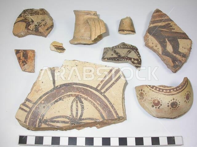9 shards of the type Midianite Pottery or Al-Qurayya ware. Yellowish clay with many black inclusions. Geometric ornaments in black and red-brown. One shard, a bottom fragment, has as decoration a rosette, two other animal figures., Crockery, earthenware, average thickness: (thickest shard) 1.5 cm., (Thinnest shard) 0.4 cm., Late Bronze Age 1300-1100 BC. Saudi Arabia