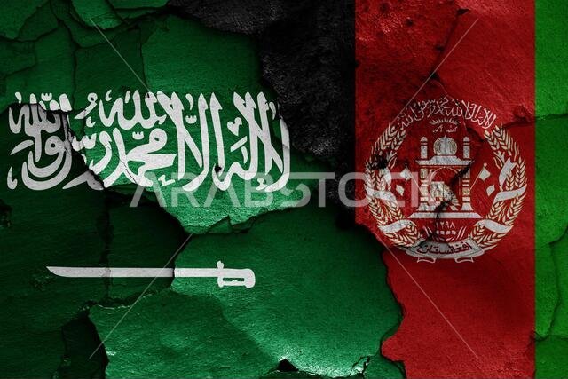 flags of Saudi Arabia and Afghanistan painted on cracked wall