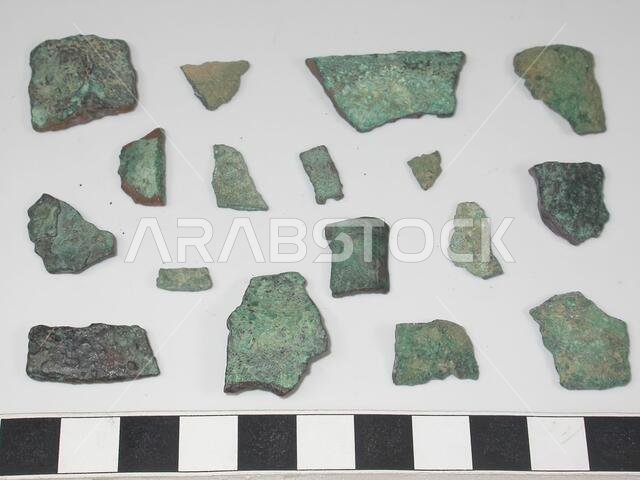 17 flat bronze fragments varying in thickness. 4 pieces fit together. One piece vaguely has a triangle engraved in it., Varia, metal, bronze, largest: L 3.2 cm, W 1.7 cm, smallest: L 0.6 cm, W 0.6 cm, Saudi Arabia