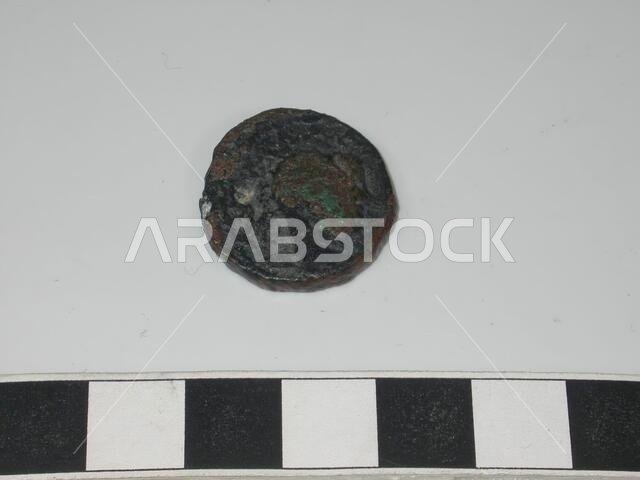 Bronze coin. On one side there is a face to distinguish, the rest of the image is unclear., Coin, metal, bronze, D 2.2 cm., Saudi Arabia