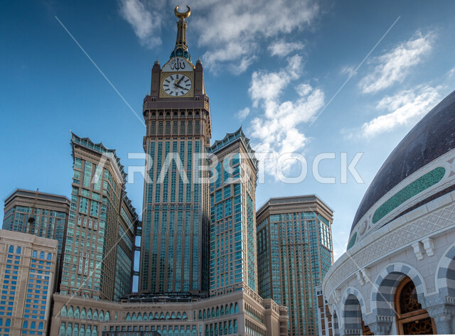 صورة جمالية من داخل الحرام المكي الشريف في مكة المكرمة ، مبنى برج الساعة الملكي في وضع النهار ، أداء مناسك الحج والعمرة ، العبادة و التقرب الى الله ، معالم دينية اسلامية في المملكة العربية السعودية