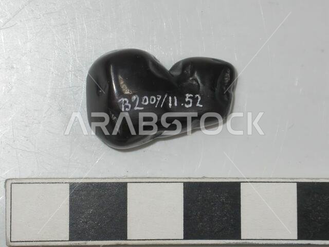 Smooth, black stone with a brown glow. Unworked. Steatite (?)., Varia, stone, L 2.7 cm, W max 1.6 cm., Saudi Arabia