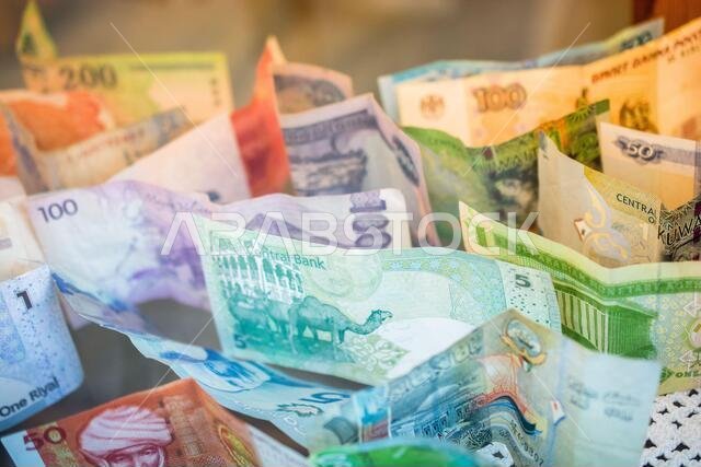 أوراق نقدية ملونة متنوعة، معظمها من شبه الجزيرة العربية. الريال السعودي، الدينار الكويتي، الريال القطري، الكرونة النرويجية