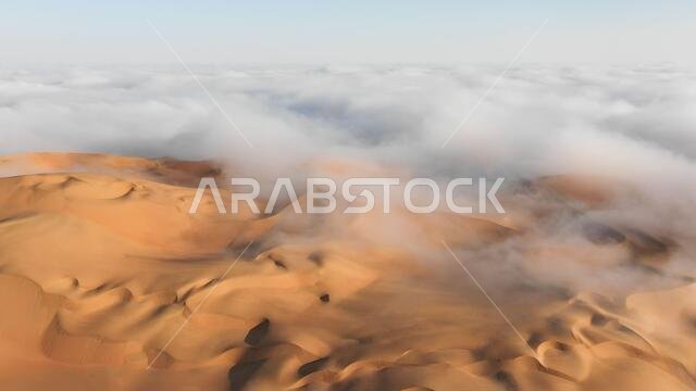 صورة جوية لكثيب رملي ضخم محاط بسحابة ضباب صباحية شتوية في الربع الخالي. صحراء ليوا، أبوظبي، الإمارات العربية المتحدة. صورة جوية لكثيب رملي ضخم محاط بسحابة ضباب صباحية شتوية في الربع الخالي. صحراء ليوا، أبوظبي، الإمارات العربية المتحدة.
