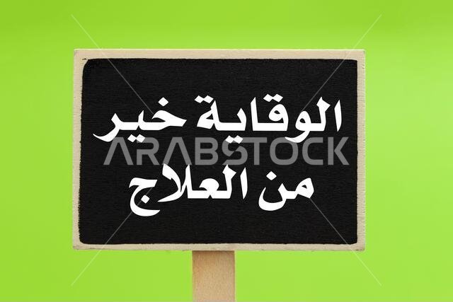 Prevention Is Better Than Cure written in Arabic (الوقاية خير من العلاج ) on a chalkboard against green background