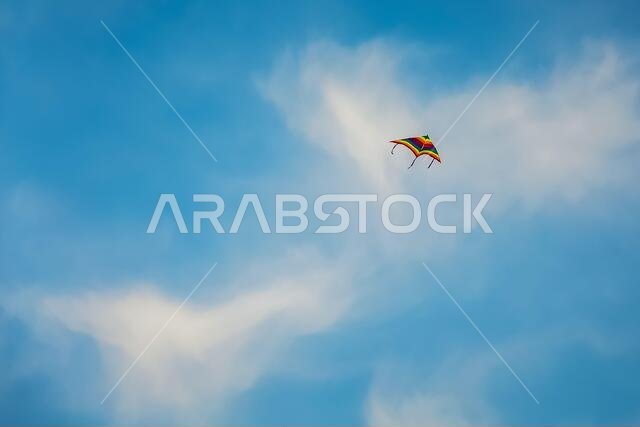 Single kite is flying on blue sky with clouds background in Fanateer beach - Jubail Saudi Arabia.