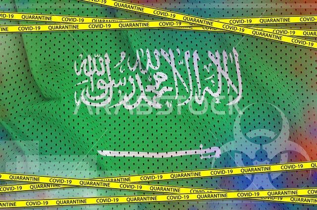 علم المملكة العربية السعودية وشريط الحجر الصحي الأصفر الخاص بفيروس كوفيد-19. مفهوم فيروس كورونا أو جائحة فيروس 2019-nCoV