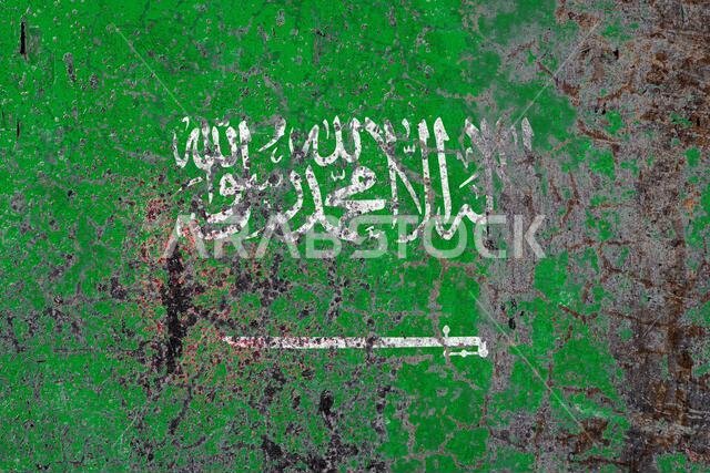National flag of Saudi Arabia on old peeling wall background.The concept of national pride and symbol of the country.
