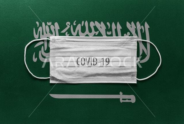 An individual face medical surgical mask on Saudi Arabia National Flag Background. Health mask. Protection against COVID-19 virus, influenza, SARS. Sa
