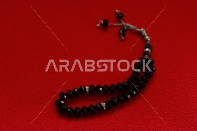black color praying beads on red background