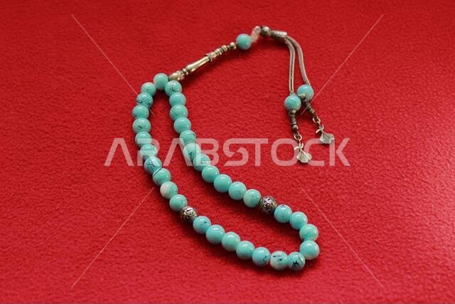 turquoise color praying beads on red background
