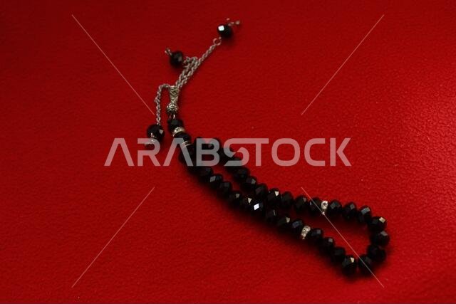 black color praying beads on red background