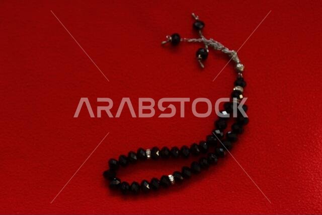 black color praying beads on red background