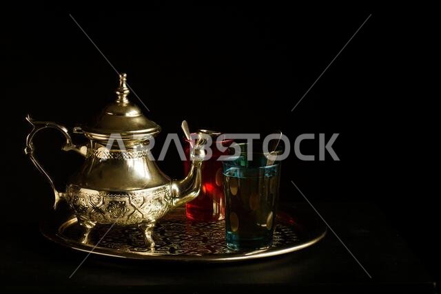 إبريق شاي عربي مع الشاي معزول على خلفية سوداء. الثقافة المغربية