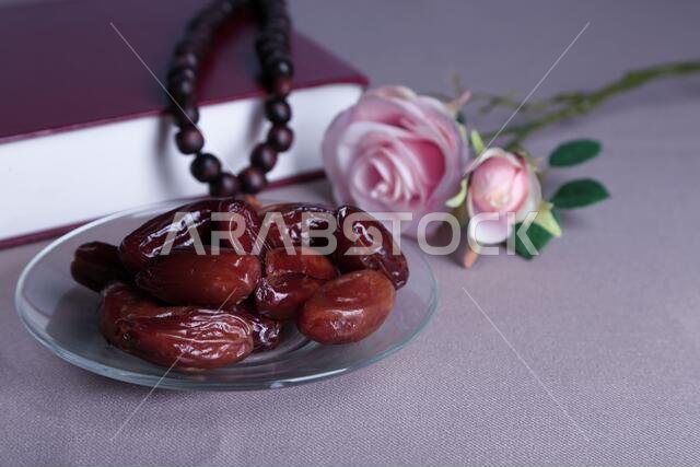 Composition with holy book,rosary and dates palm, on gray background