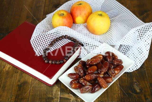 لوحة فنية تضم أطعمة رمضانية تقليدية، على خلفية خشبية.