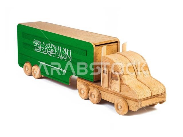 صورة مقرّبة لشاحنة لعبة خشبية عليها علم المملكة العربية السعودية. مفهوم الاستيراد والتصدير، والنقل، والتوصيل الوطني للبضائع صورة مقرّبة لشاحنة لعبة خشبية عليها علم المملكة العربية السعودية. مفهوم الاستيراد والتصدير، والنقل، والتوصيل الوطني للبضائع