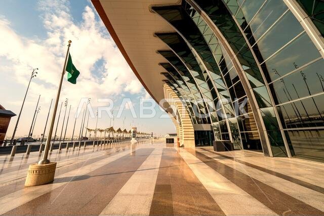 العلم السعودي يرفرف في مهب الريح أمام مبنى الركاب رقم 1 الجديد كلياً في مطار الملك عبد العزيز الدولي (جدة) في جدة، المملكة العربية السعودية