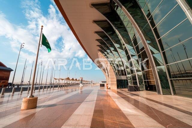 Saudi flag waving in the wind in front of the brand new Terminal 1 at the King Abdulaziz International Airport (JED) in Jeddah, Saudi Arabia