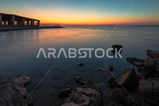 Dramatic sunrise with silky water view in Al uqair ruined fort sea side Saudi Arabia.