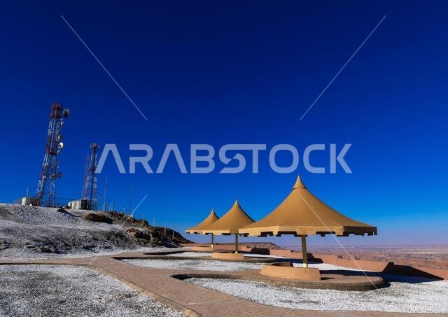 Cellular transmission towers and umbrellas at the top of a hill, Al Madinah Province, Alula, Saudi Arabia