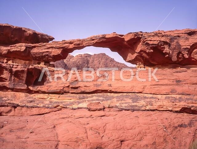 Jordan. Colourful desert mountain landscapes at the rock arch of Al Kharza at the UNESCO World Heritage Site of Wadi Rum near the port of Aqaba in southern Jordan