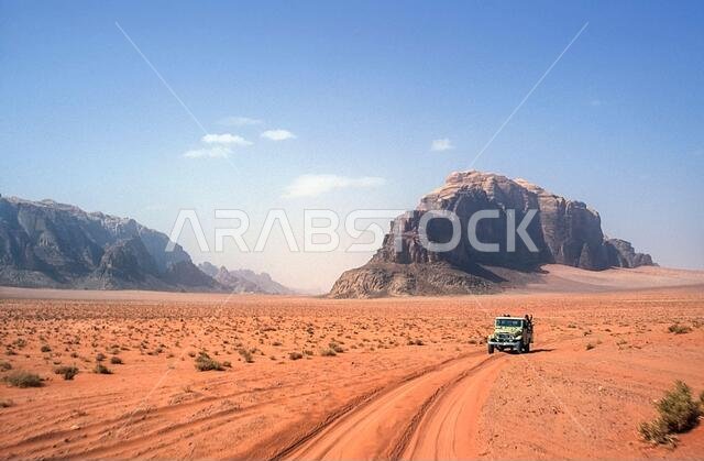 Jordan. Colourful desert mountain landscapes with tourist 4x4 SUV's at the UNESCO World Heritage Site of Wadi Rum near the port of Aqaba in southern Jordan  associated with  Lawrence of Arabia.