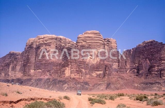 Jordan. Colourful desert mountain landscapes with tourist 4x4 SUV's at the UNESCO World Heritage Site of Wadi Rum near the port of Aqaba in southern Jordan  associated with  Lawrence of Arabia.
