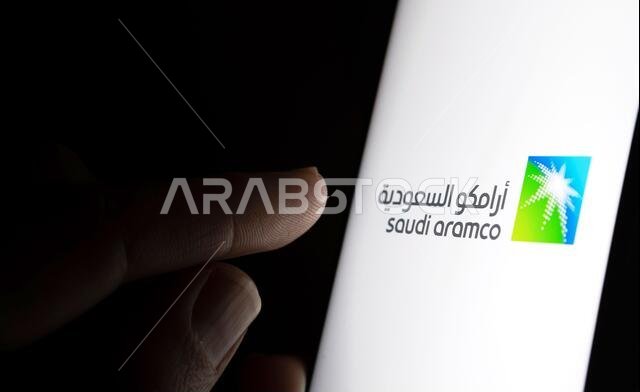 Saudi Aramco company logo on a white screen and finger pointing at it.  Saudi Arabian Oil Company is a  petroleum and natural gas company.