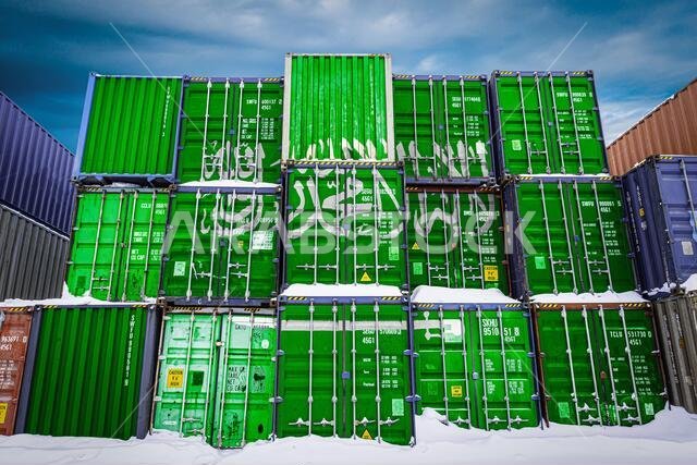 The national flag of Saudi Arabia  on a large number of metal containers for storing goods stacked in rows on top of each other. Conception of storage