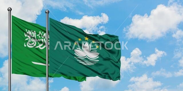 يرفرف علم المملكة العربية السعودية وعلم ماكاو معاً في مهب الريح أمام سماء زرقاء صافية تتخللها غيوم بيضاء. مفهوم الدبلوماسية، العلاقات الدولية.