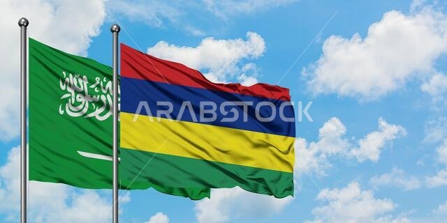 Saudi Arabia and Mauritius flag waving in the wind against white cloudy blue sky together. Diplomacy concept, international relations.