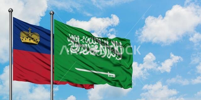 يرفرف علما ليختنشتاين والمملكة العربية السعودية معاً في مهب الريح أمام سماء زرقاء صافية تتلألأ بالغيوم البيضاء. مفهوم الدبلوماسية، العلاقات الدولية.