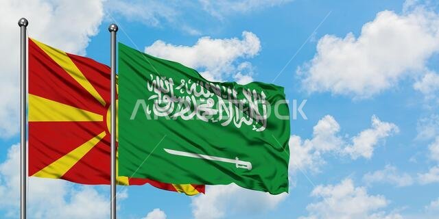 يرفرف علم مقدونيا وعلم المملكة العربية السعودية معاً في مهب الريح أمام سماء زرقاء صافية تتلألأ بالغيوم البيضاء. مفهوم الدبلوماسية، العلاقات الدولية.