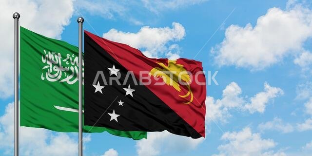 Saudi Arabia and Papua New Guinea flag waving in the wind against white cloudy blue sky together. Diplomacy concept, international relations.