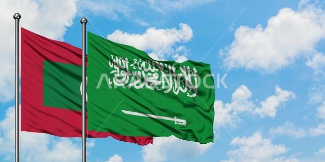 Maldives and Saudi Arabia flag waving in the wind against white cloudy blue sky together. Diplomacy concept, international relations.