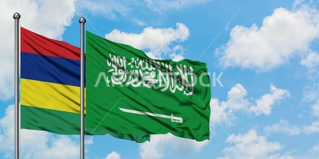 يرفرف علما موريشيوس والمملكة العربية السعودية معاً في مهب الريح أمام سماء زرقاء صافية تتلألأ فيها الغيوم البيضاء. مفهوم الدبلوماسية، العلاقات الدولية.