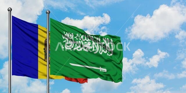 يرفرف علم مولدوفا وعلم المملكة العربية السعودية معاً في مهب الريح أمام سماء زرقاء ملبدة بالغيوم البيضاء. مفهوم الدبلوماسية، العلاقات الدولية.
